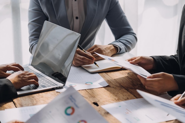 Financial analysts analyze business financial reports on a digital tablet planning investment project during a discussion at a meeting of corporate showing the results of their successful teamwork