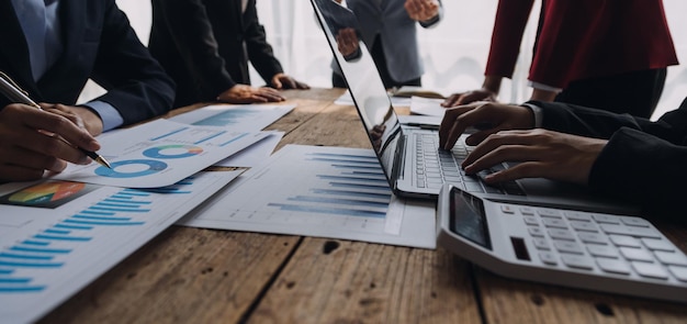 Financial analysts analyze business financial reports on a digital tablet planning investment project during a discussion at a meeting of corporate showing the results of their successful teamwork