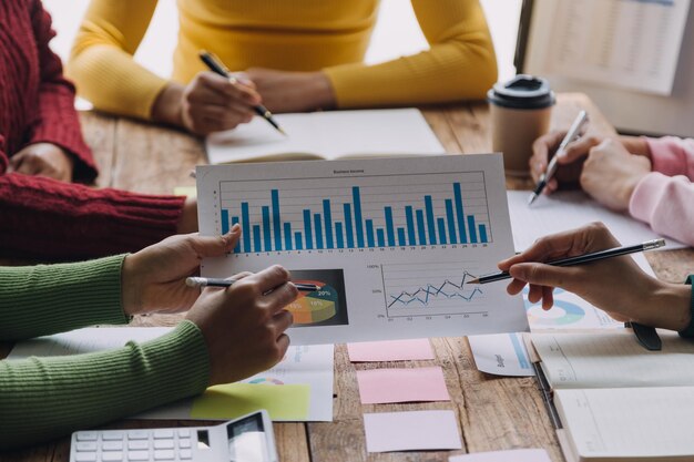 Financial analysts analyze business financial reports on a digital tablet planning investment project during a discussion at a meeting of corporate showing the results of their successful teamwork