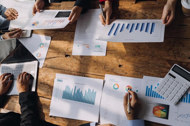 Financial analysts analyze business financial reports on a digital tablet planning investment project during a discussion at a meeting of corporate showing the results of their successful teamwork