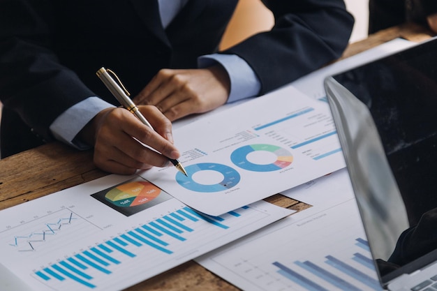 Financial analysts analyze business financial reports on a digital tablet planning investment project during a discussion at a meeting of corporate showing the results of their successful teamwork