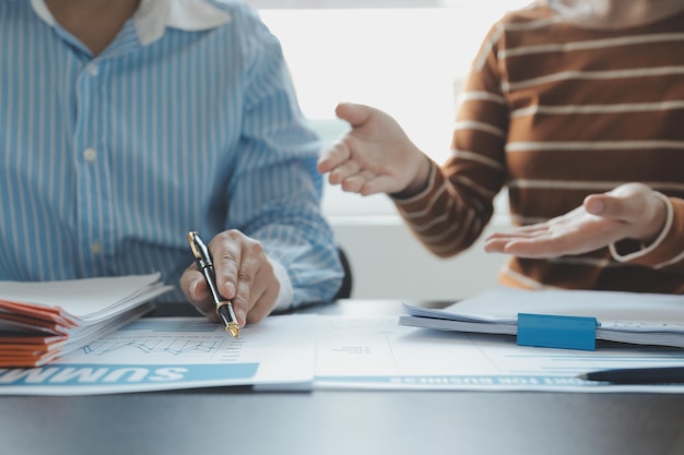 Financial analysts analyze business financial reports on a digital tablet planning investment project during a discussion at a meeting of corporate showing the results of their successful teamwork