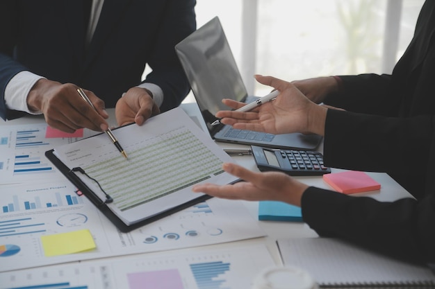 Financial analysts analyze business financial reports on a digital tablet planning investment project during a discussion at a meeting of corporate showing the results of their successful teamwork