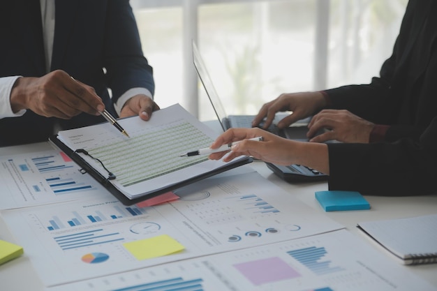 Financial analysts analyze business financial reports on a digital tablet planning investment project during a discussion at a meeting of corporate showing the results of their successful teamwork