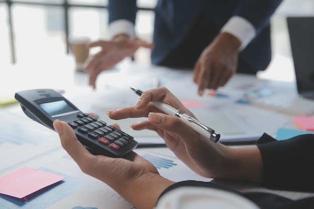 Financial analysts analyze business financial reports on a digital tablet planning investment project during a discussion at a meeting of corporate showing the results of their successful teamwork