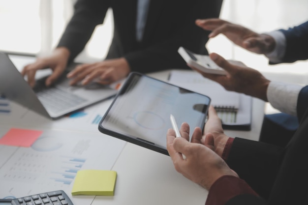 Financial analysts analyze business financial reports on a digital tablet planning investment project during a discussion at a meeting of corporate showing the results of their successful teamwork