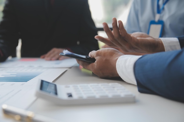 Financial analysts analyze business financial reports on a digital tablet planning investment project during a discussion at a meeting of corporate showing the results of their successful teamwork