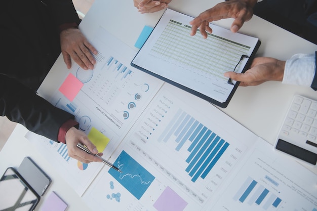 Financial analysts analyze business financial reports on a digital tablet planning investment project during a discussion at a meeting of corporate showing the results of their successful teamwork