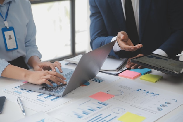 Financial analysts analyze business financial reports on a digital tablet planning investment project during a discussion at a meeting of corporate showing the results of their successful teamwork