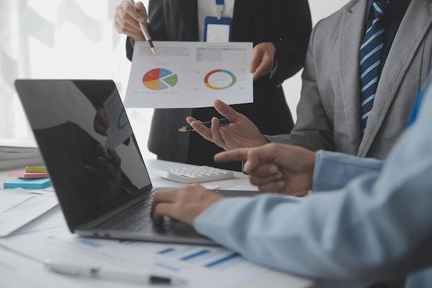 Financial analysts analyze business financial reports on a digital tablet planning investment project during a discussion at a meeting of corporate showing the results of their successful teamwork