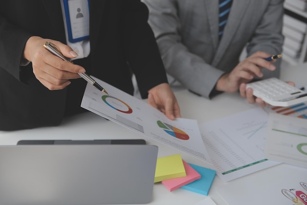 Financial analysts analyze business financial reports on a digital tablet planning investment project during a discussion at a meeting of corporate showing the results of their successful teamwork.