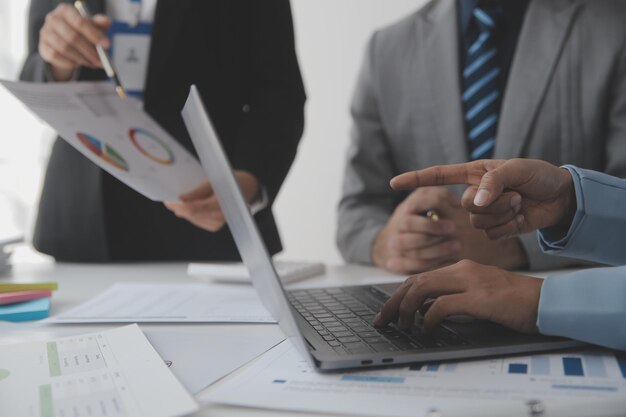 Financial analysts analyze business financial reports on a digital tablet planning investment project during a discussion at a meeting of corporate showing the results of their successful teamwork.