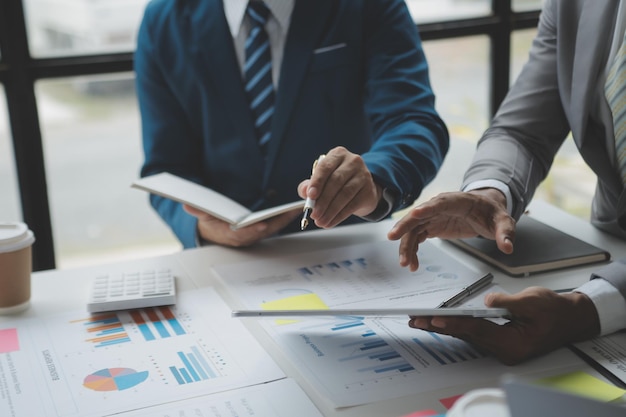 Photo financial analysts analyze business financial reports on a digital tablet planning investment project during a discussion at a meeting of corporate showing the results of their successful teamwork