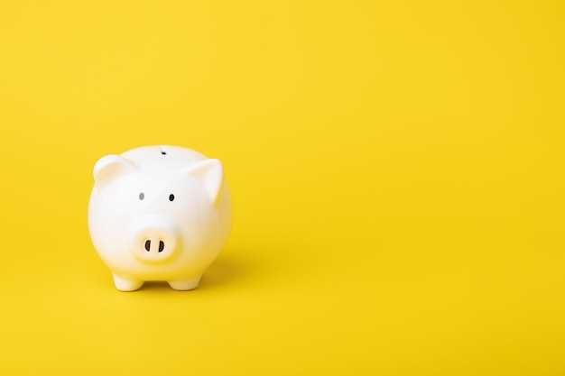 Financial concept The idea of saving money Close up white new piggy bank on yellow color copy space Saving money Finance or business concept