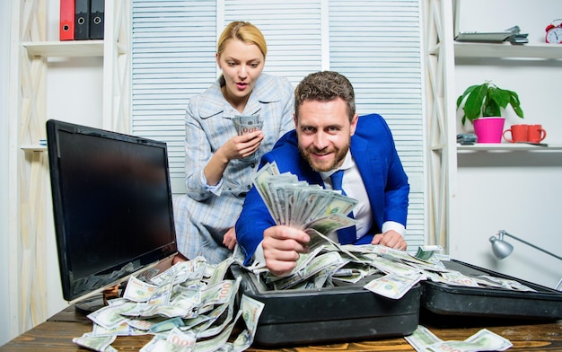 Financial success Man businessman and woman secretary with pile dollar banknotes Profit and richness concept Businessman near cash dollars profit Huge profit concept Counting money profit