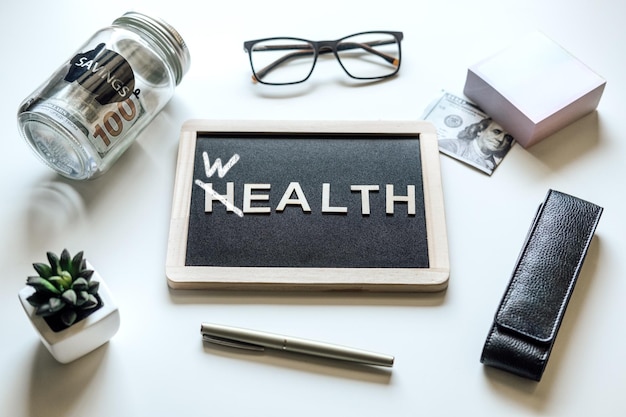 Financial wellness black frame with word wealth to health on table with mason jar saving bank