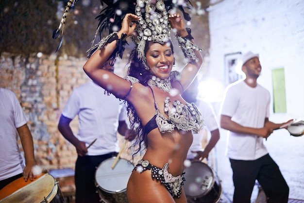 In fine feather Shot of an attractive female Mardi Gras dancer in an elaborate beaded costume and feather headdress