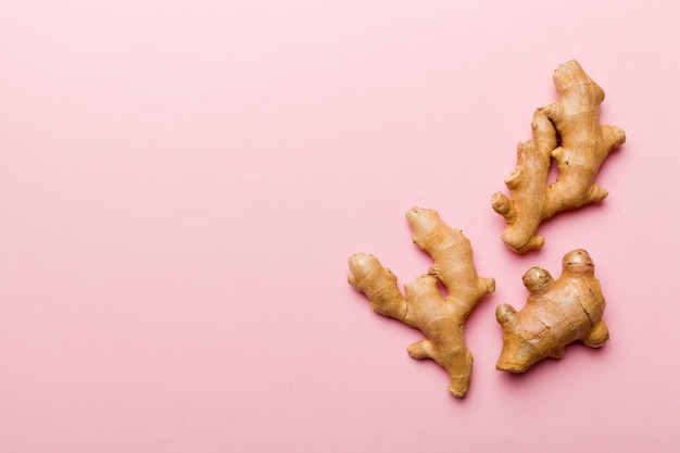 Finely dry Ginger powder in bowl with green leaves isolated on colored background. top view flat lay.