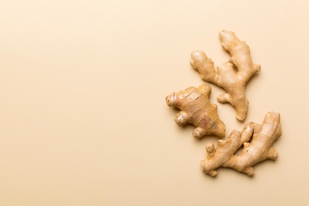 Finely dry Ginger powder in bowl with green leaves isolated on colored background top view flat lay