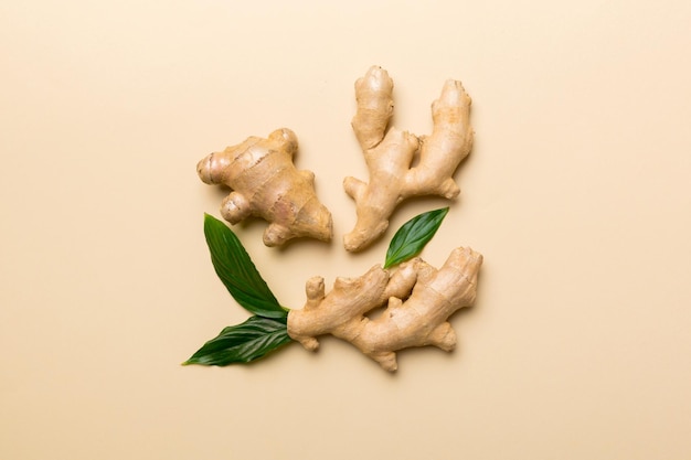 Finely dry Ginger powder in bowl with green leaves isolated on colored background top view flat lay