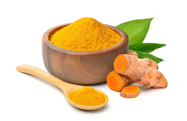 Finely dry Turmeric powder in wooden bowl with  rhizome sliced and green leaves isolated on white background