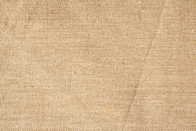 Finely textured background of beige linen fabric