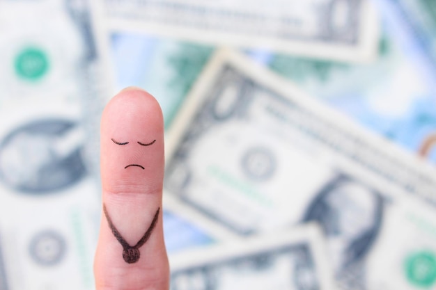 Finger art of a lonely sad man on the background of money