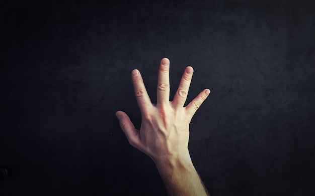 Finger gestures Male hands on a gray background Gesticulation with hands