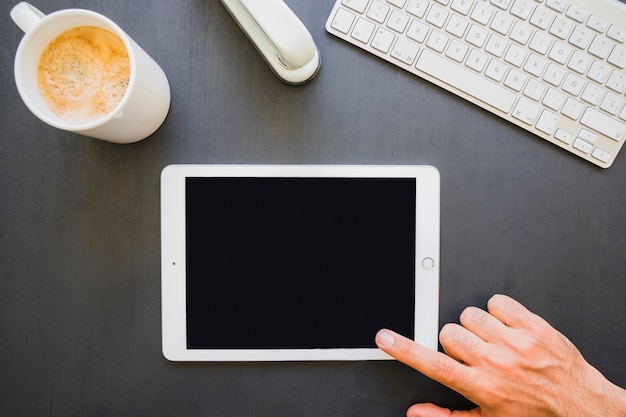 Finger touching tablet's screen at work