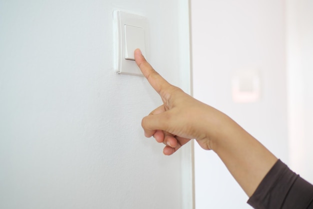 A finger turning on lighting switch