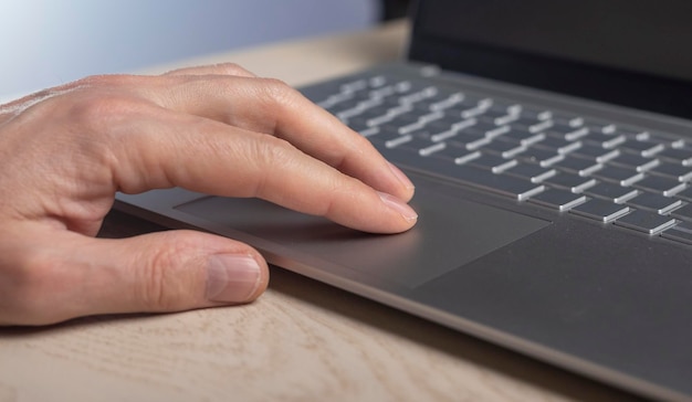 Fingers on laptop touchpad scrolling process close up