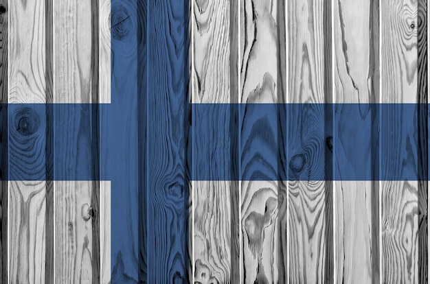 Finland flag depicted in bright paint colors on old wooden wall.