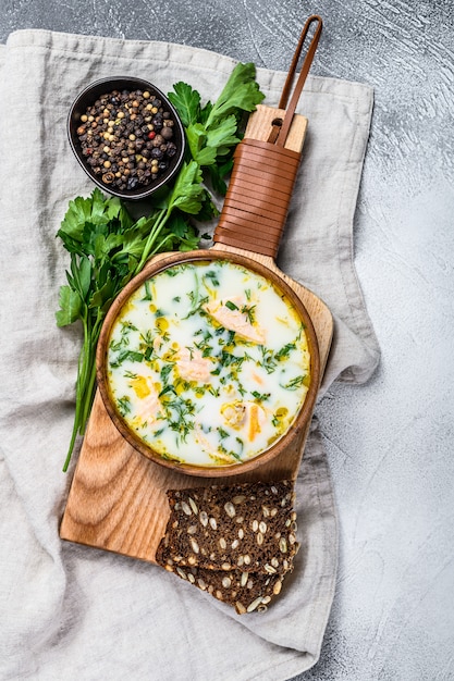 Finnish Creamy Fish Soup with Salmon and Potatoes.  Gray background, top view.