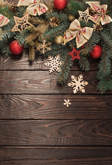 Fir branches with Christmas decor on old dark wooden background