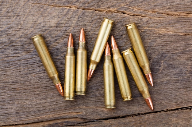 Fire arm or rifle bullet cartridges on a old wooden table