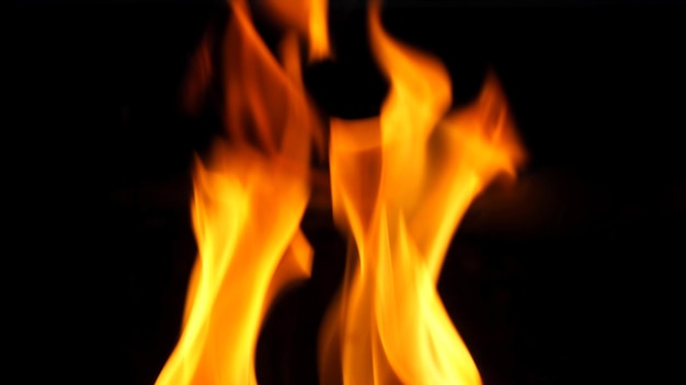 Photo fire blazing while cooking on black color background and close-up shot.