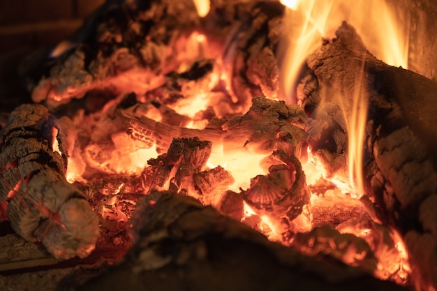 Fire and embers of oak wood in a comfortable fireplace in winter.