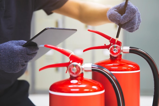 Fire extinguisher has hand engineer checking pressure gauges