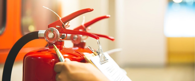 Fire extinguisher has hand engineer checking pressure gauges