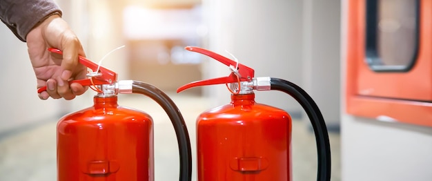 Fire extinguishers has hand engineer checking handle fire extinguisher to prepare fire equipment for protection and prevent in emergency case and safety or rescue and alarm system training concept