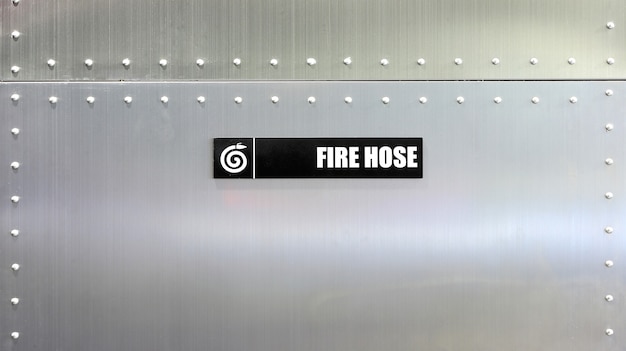 Fire hose label against metal wall