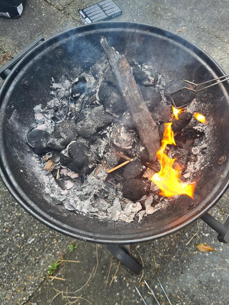 A fire pit with a yellow flame and a stick of wood on it