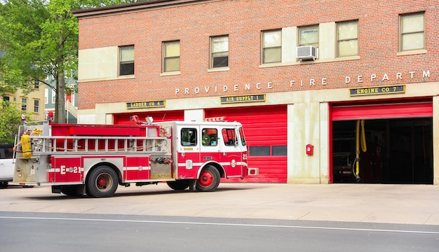 A fire truck is parked in front of a building that says " the fire department ".