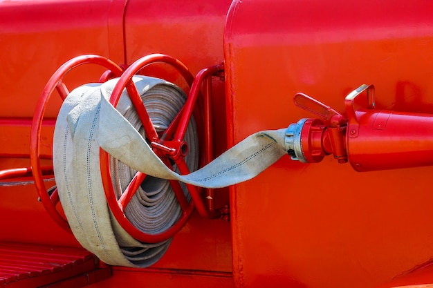 Photo fire truck with firehose. side view of red municipal fire engine standing idle.