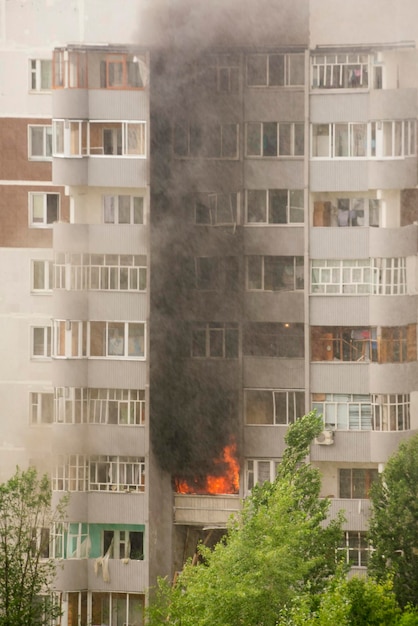 Fire with black smoke in multistory apartment building Toned