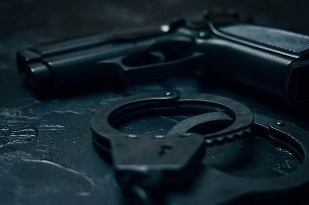 Firearms and handcuffs close up on black table gun for law enforcement ammunition for the arrest of criminals