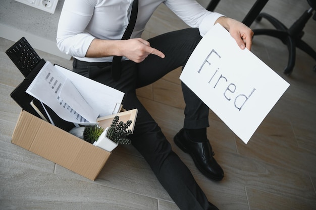 Photo fired employee holding fired sign in hand