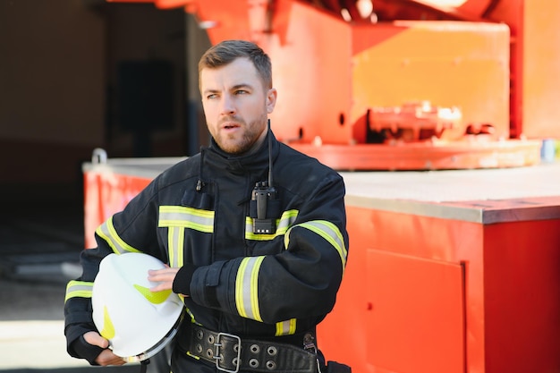 Firefighter portrait on duty Photo fireman with gas mask and helmet near fire engine