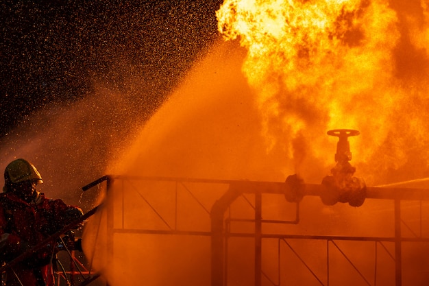 Firefighter spraying down flame from pipeline