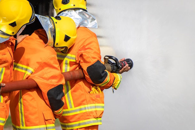 Firefighter trainingInstructor Training on the use of fire hoses extinguisher for fighting fire in the factory